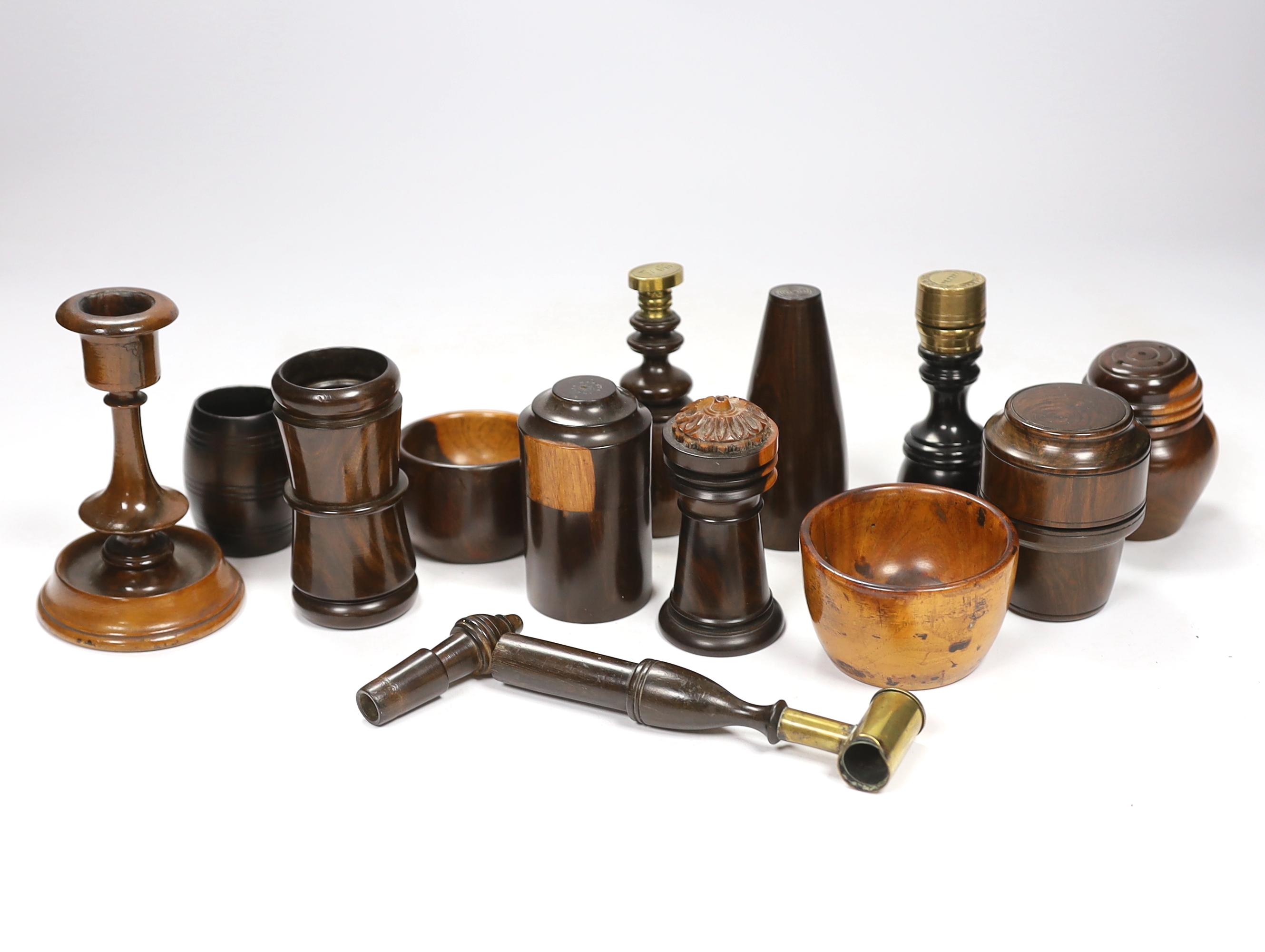 A collection of 19th/20th century lignum vitae vessels and desk items, to include a pepper pot, salt pot, two desk seals, a whistle, a candlestick etc.